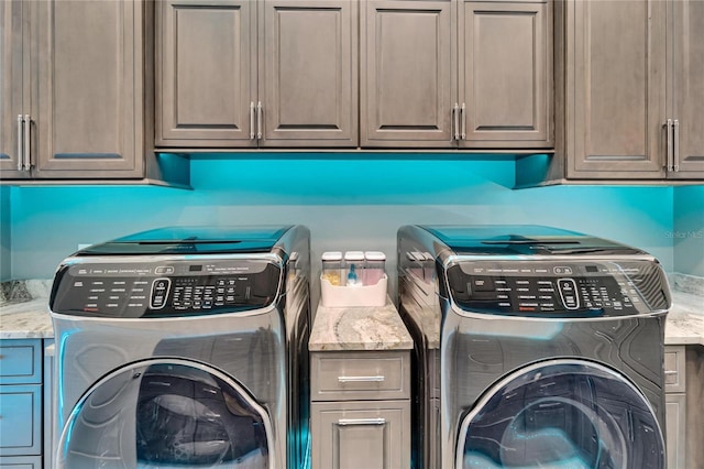 washroom featuring cabinet space and washing machine and clothes dryer