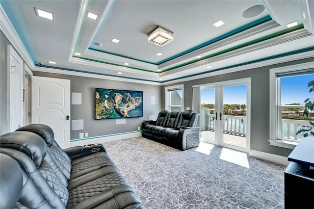 carpeted cinema featuring a raised ceiling, baseboards, crown molding, and french doors