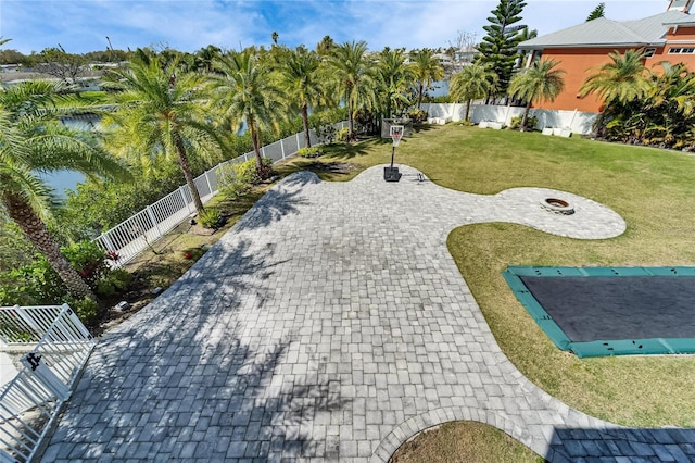 exterior space with a yard, decorative driveway, a patio area, and a fenced backyard