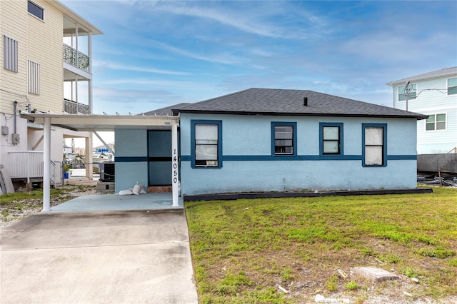 view of front of property featuring a carport and a front lawn