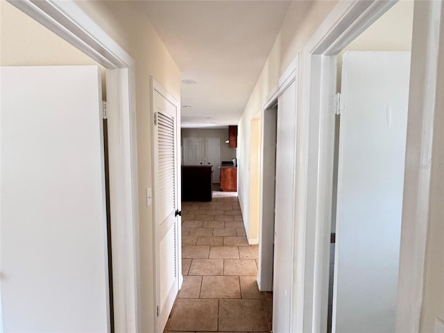 hall with tile patterned floors