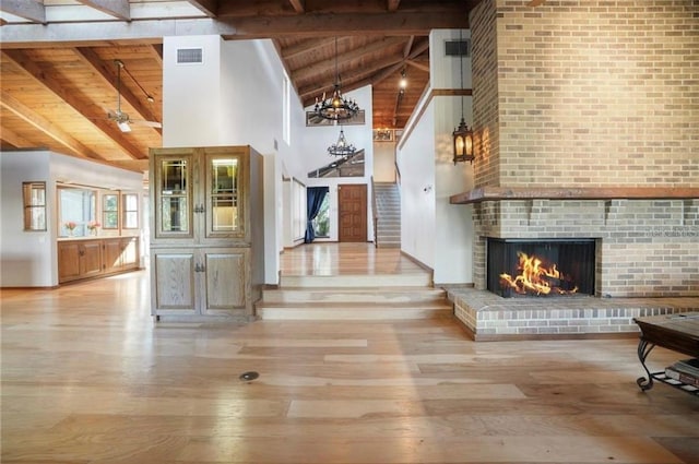 interior space featuring wood ceiling, a fireplace, a wealth of natural light, and light wood-type flooring