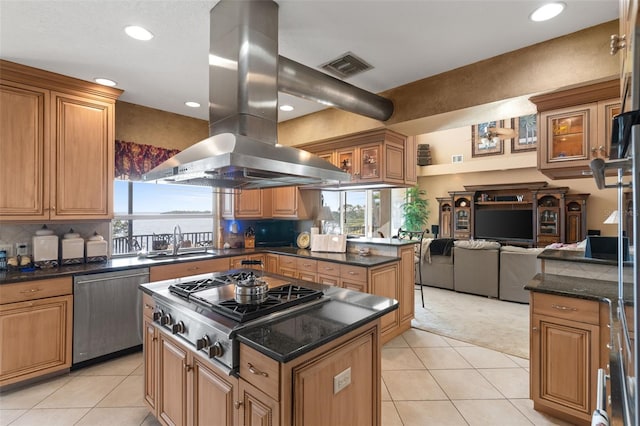 kitchen featuring visible vents, stainless steel appliances, a sink, island range hood, and a wealth of natural light