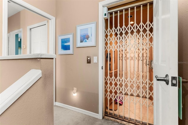 corridor featuring baseboards and carpet floors