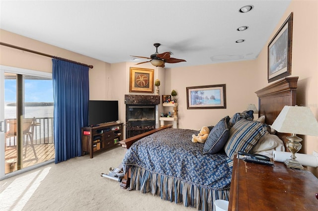 bedroom with recessed lighting, carpet, access to outside, a ceiling fan, and a glass covered fireplace
