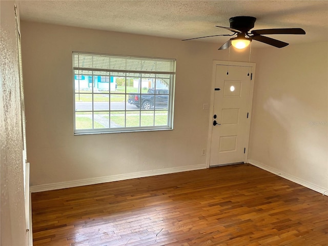 foyer featuring ceiling fan, dark hardwood / wood-style floors, and a textured ceiling