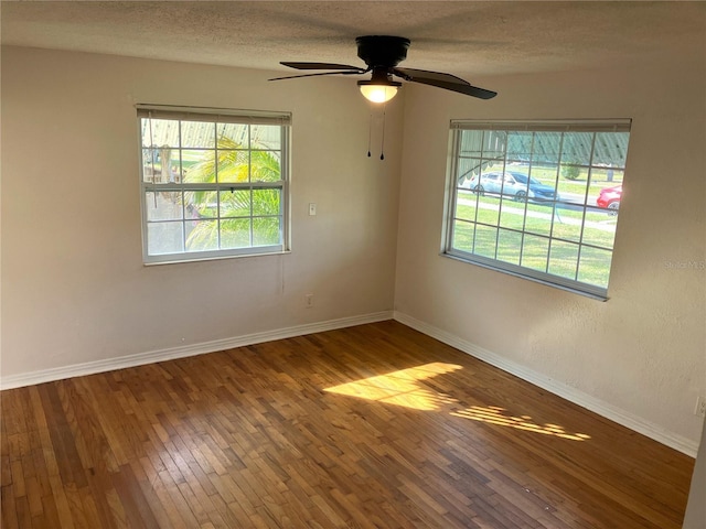 empty room featuring hardwood / wood-style flooring, ceiling fan, and a textured ceiling