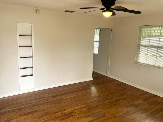 spare room featuring dark hardwood / wood-style floors, a textured ceiling, and ceiling fan