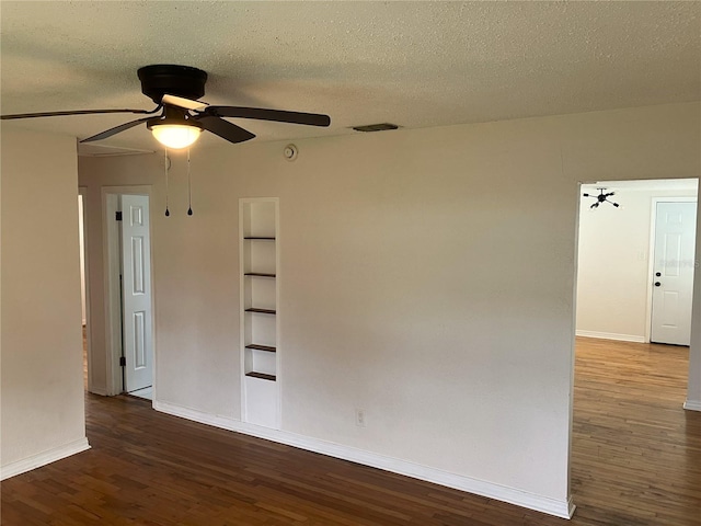 spare room featuring ceiling fan, dark hardwood / wood-style floors, and a textured ceiling