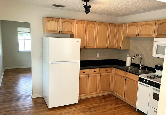 kitchen featuring hardwood / wood-style flooring, white appliances, sink, and backsplash