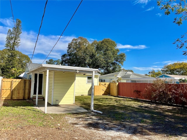 back of property with a yard and a patio