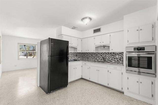 kitchen featuring freestanding refrigerator, oven, light countertops, white cabinetry, and a sink