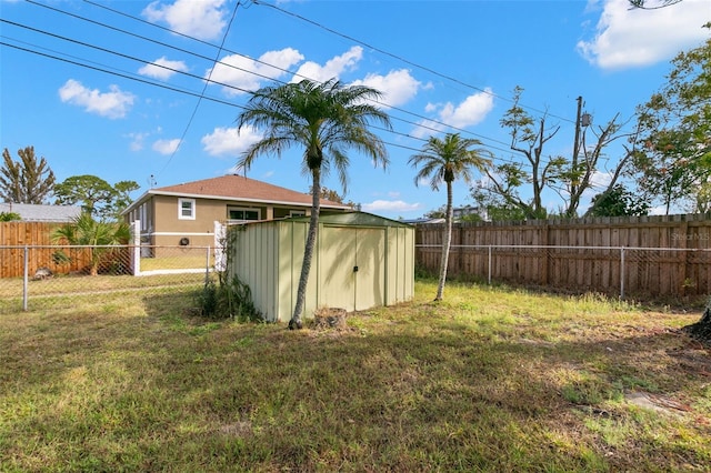 view of yard with a fenced backyard, an outdoor structure, and a shed