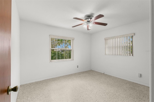 spare room featuring ceiling fan and baseboards