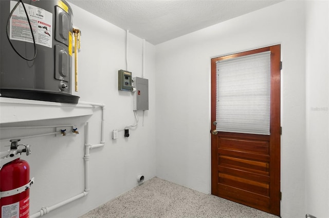 clothes washing area with a textured ceiling, laundry area, and electric panel