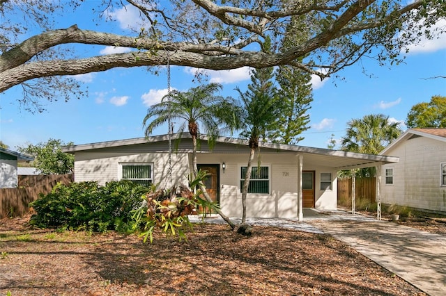 single story home featuring a carport, driveway, and fence