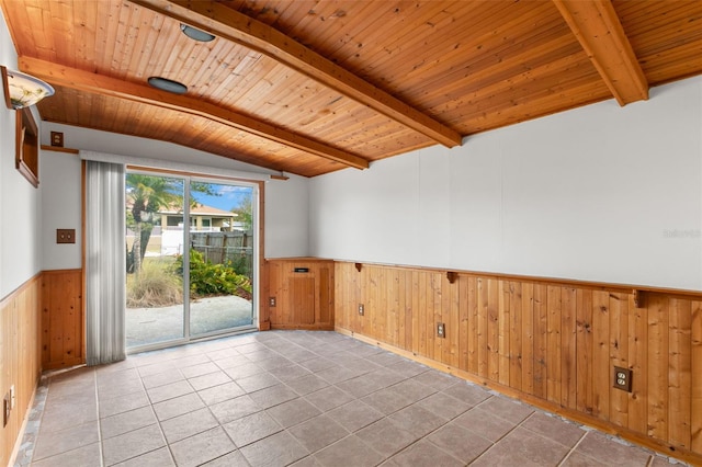 spare room with wooden ceiling, a wainscoted wall, lofted ceiling with beams, and light tile patterned floors