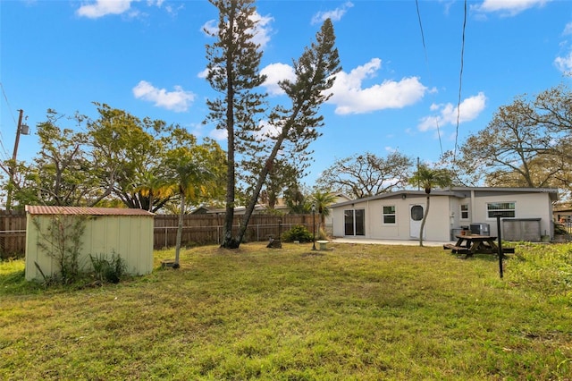 view of yard featuring a patio, a shed, an outdoor structure, and a fenced backyard