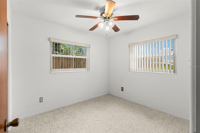 spare room featuring ceiling fan and baseboards