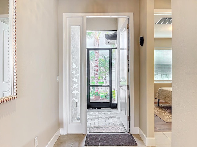 entryway with baseboards, visible vents, and light tile patterned floors