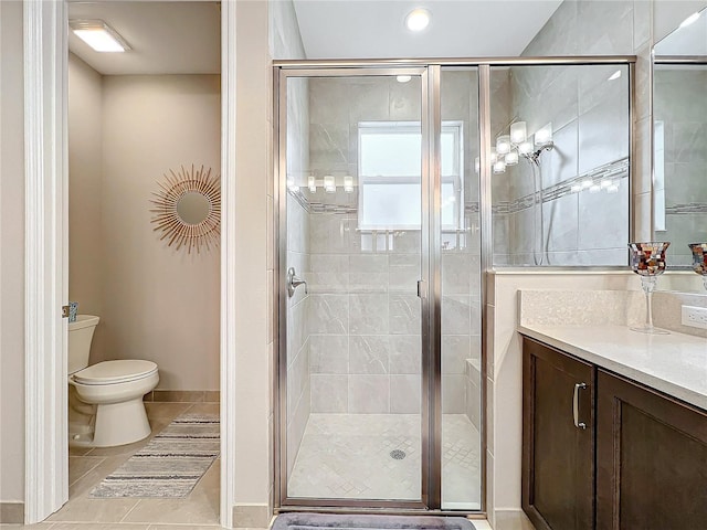 bathroom with a shower stall, vanity, tile patterned flooring, and toilet