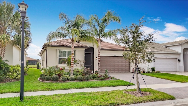 mediterranean / spanish home with a tiled roof, stucco siding, driveway, and a garage