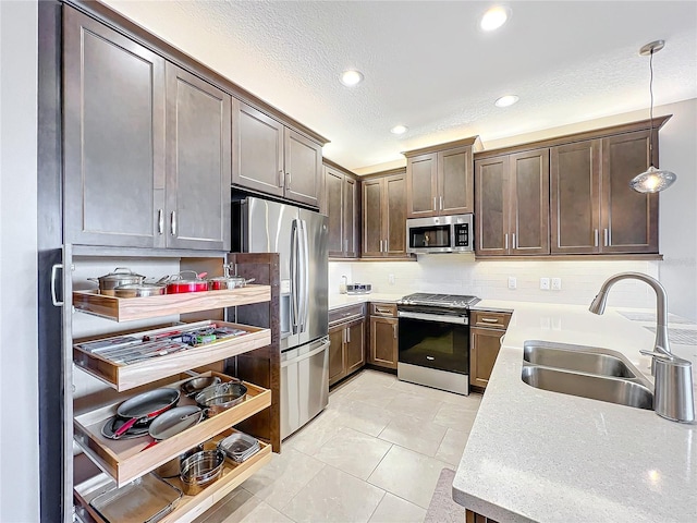 kitchen with stainless steel appliances, light countertops, a sink, and recessed lighting