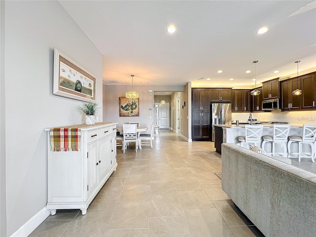 living area featuring baseboards, recessed lighting, and light tile patterned flooring