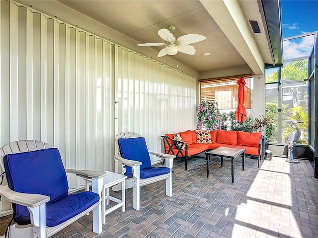 view of patio with a ceiling fan, glass enclosure, and an outdoor hangout area