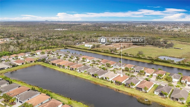 aerial view with a view of trees, a water view, and a residential view
