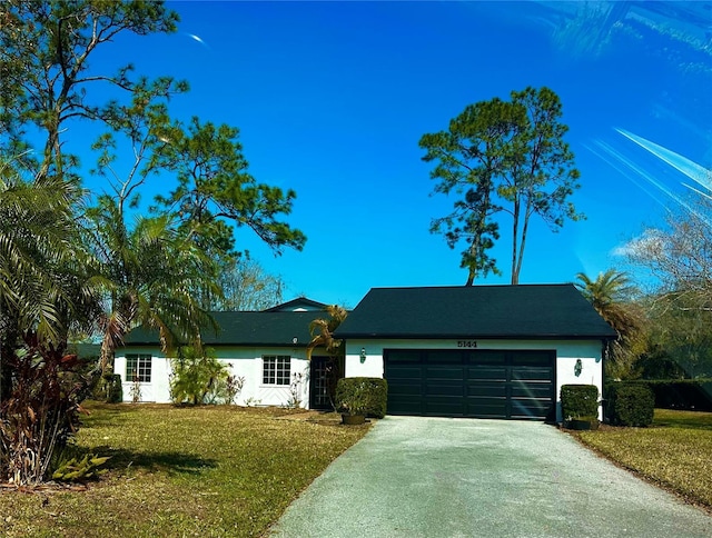 ranch-style house featuring driveway, a front lawn, an attached garage, and stucco siding