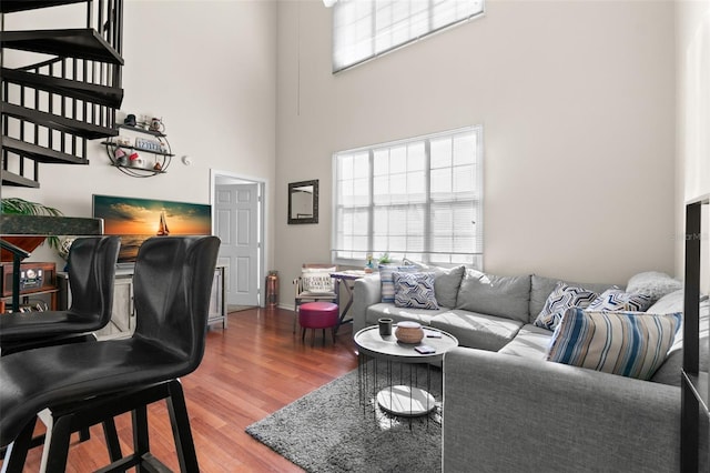 living room featuring hardwood / wood-style flooring and a towering ceiling