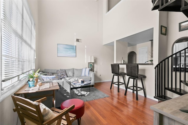 living room featuring wood-type flooring and a high ceiling