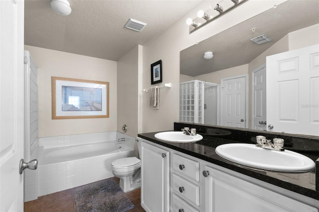 full bathroom featuring shower with separate bathtub, vanity, a textured ceiling, toilet, and tile patterned floors