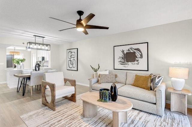 living room featuring ceiling fan and light hardwood / wood-style floors