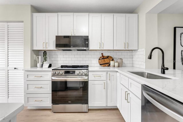 kitchen featuring sink, appliances with stainless steel finishes, and white cabinetry