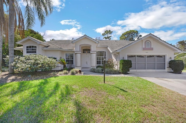 single story home featuring a garage, a front yard, and stucco siding