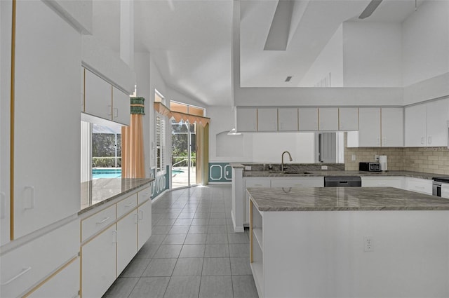 kitchen featuring a center island, decorative backsplash, white cabinetry, a sink, and light tile patterned flooring