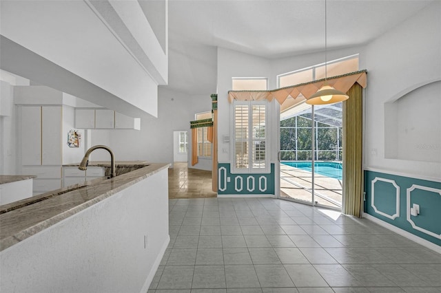 kitchen with hanging light fixtures, light tile patterned floors, and baseboards