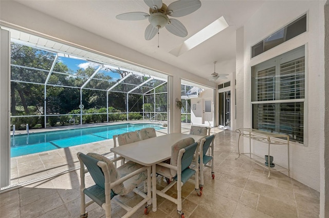 pool with glass enclosure, a ceiling fan, and a patio