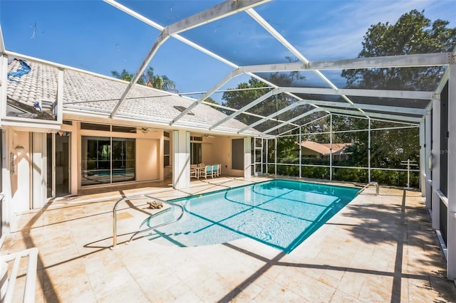 pool featuring a ceiling fan, glass enclosure, and a patio