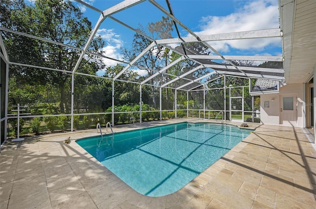 pool featuring glass enclosure and a patio