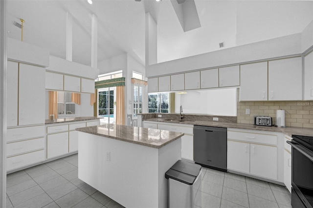 kitchen with a sink, a kitchen island, white cabinetry, and dishwasher