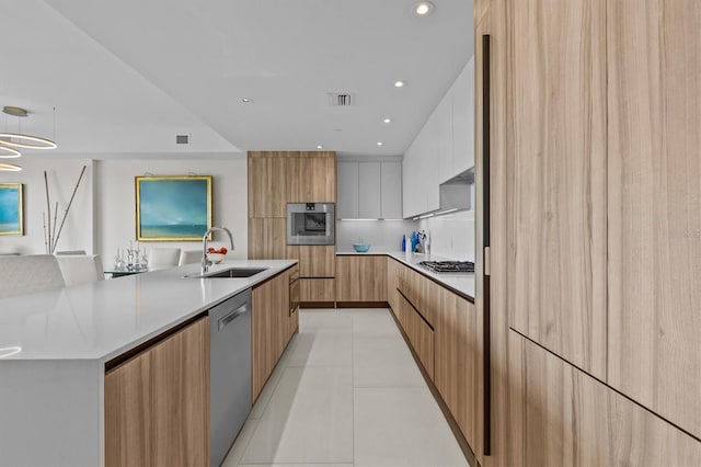 kitchen featuring light tile patterned flooring, sink, white cabinetry, hanging light fixtures, and stainless steel appliances