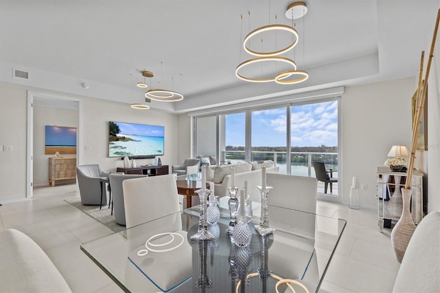 tiled dining space featuring a tray ceiling