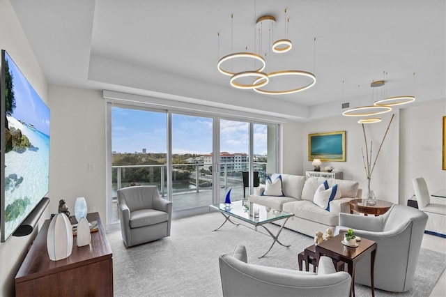 carpeted living room featuring a notable chandelier