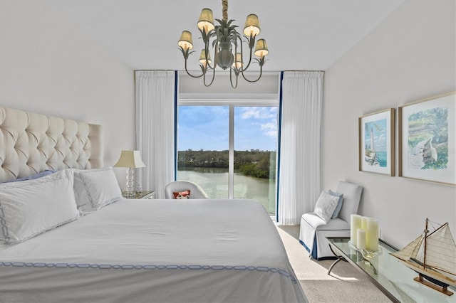 bedroom featuring a water view, access to outside, and a notable chandelier