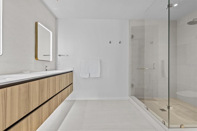 bathroom featuring a shower with door, vanity, and tile patterned flooring