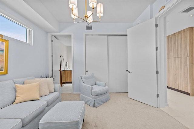 carpeted living room with an inviting chandelier