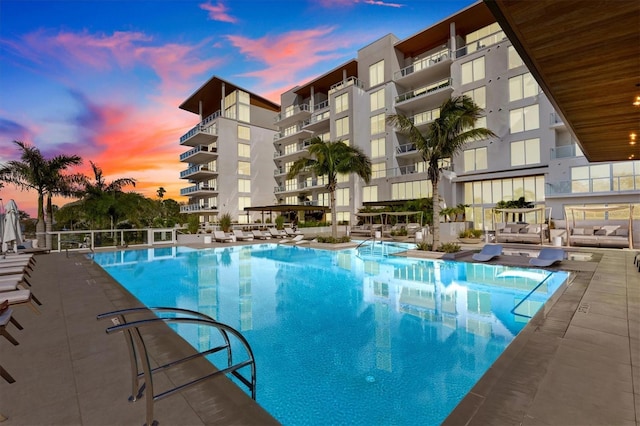 pool at dusk featuring a patio